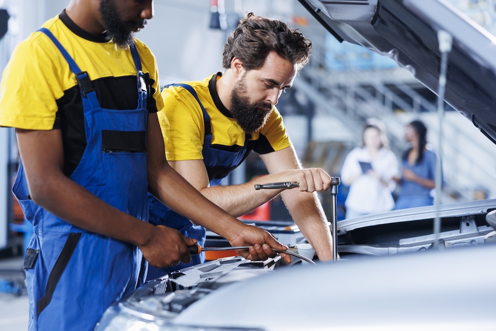 two men working on a car engine